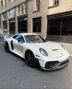 a white sports car parked in front of a building