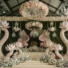 an elaborate floral display with flowers and chandelier hanging from it's ceiling