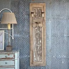 an old wooden door on the wall next to a lamp