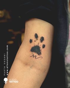 a dog paw tattoo on the left arm