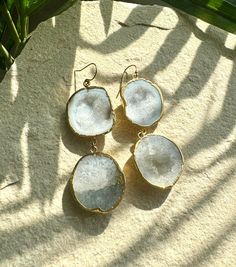 Discover the raw beauty of nature with these stunning white geode earrings. Each piece features a naturally unique geode stone, showcasing a sparkling crystal quartz center that add a touch of elegance to any outfit. Perfect for both casual and formal occasions, these earrings are a versatile addition to your jewelry collection. 3" Long 14k Gold-filled Earring Hooks White Bohemian Earrings With Natural Stones, Bohemian White Earrings With Natural Stones, Elegant Natural Stone Geodes As Gift, White Crystal Gemstone Drop Earrings, White Natural Stones Earrings For Wedding, White Natural Stone Wedding Earrings, White Dangle Earrings With Natural Stones, White Drop Earrings With Natural Stones, Elegant Raw Jewelry Gift