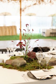 the table is set with wine glasses and place settings