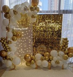 a table topped with balloons and gold decorations