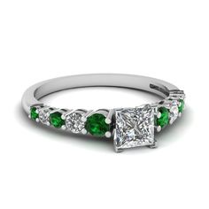 a princess cut diamond and emerald engagement ring in white gold with diamonds on each side