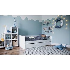 a child's bedroom with blue walls and white furniture, including a toy chest