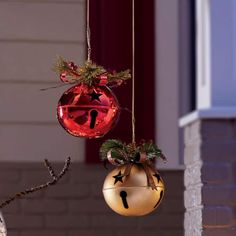 two christmas ornaments hanging from the side of a house