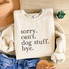 a sweater that says sorry, can't, dog stuff bye next to some shoes