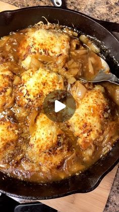 a skillet filled with chicken and onions on top of a wooden cutting board next to a knife