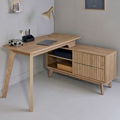 a wooden desk with drawers and a lamp next to it