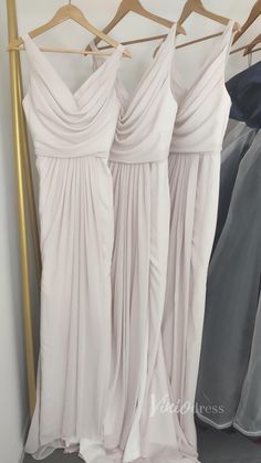 three bridesmaid dresses hanging on a rack