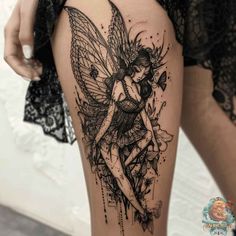 a woman's thigh with a black and white tattoo design on her leg, featuring a fairy