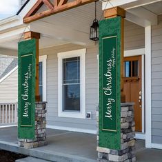 two green signs on the front porch of a house