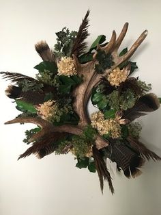 an antler's head with flowers and leaves on it is mounted on the wall