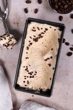 an ice cream dish with chocolate chips and coffee beans next to it on a table