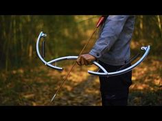 a man holding an arrow and bow in the woods