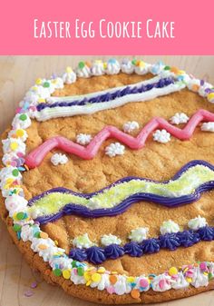 a cookie decorated with icing and sprinkles sitting on a table next to plates