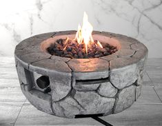 a stone fire pit sitting on top of a tile floor