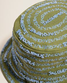 a green hat with blue writing on it