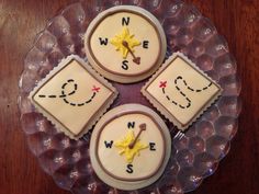 three decorated cookies sitting on top of a glass plate