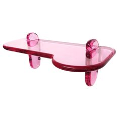 a pink shelf with two glass shelves on each side and one shelf holding an object