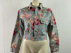 "Vintage 1980s or 90s Ralph Lauren denim trucker jacket, jean jacket. Made of floral print cotton denim. Made in the style of Levi's type 1 jacket with pleated front, single chest pocket and a buckle back. Has a button down front and button cuffs. Size small. Actual measurements are: 38\" at the bust 31\" at the waist (uncinched) 18\" shoulder seam to shoulder seam 21.5\" shoulder seam to end of cuff 19.5\" overall length In very good condition." Long Sleeve Cotton Denim Jacket With Floral Print, Casual Floral Print Denim Jacket For Summer, Casual Summer Denim Jacket With Floral Print, Fitted Casual Denim Jacket With Floral Print, Casual Fitted Denim Jacket With Floral Print, Vintage Long Sleeve Denim Jacket For Spring, Casual Cotton Denim Jacket With Floral Print, Fitted Denim Jacket With Floral Print, Retro Cotton Denim Jacket For Spring