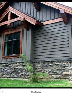 a gray house with wood trim and windows