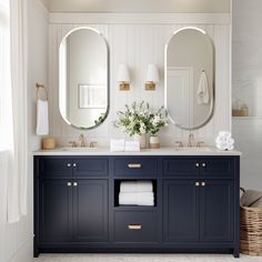 a bathroom with two sinks and three mirrors