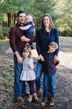 a family posing for a photo in the woods