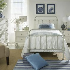 a bedroom with white furniture and blue accents