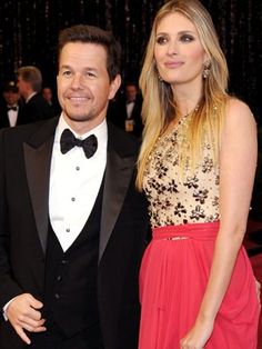 a man and woman standing next to each other on a red carpet