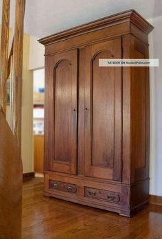 a wooden armoire sitting on top of a hard wood floor