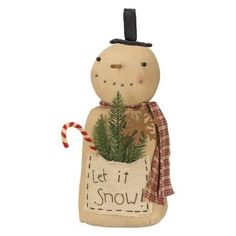 a snowman with a hat and scarf holding a christmas tree in a sack that says let it snow