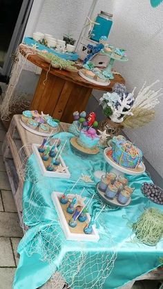 a table topped with lots of cakes and cupcakes on top of it's sides