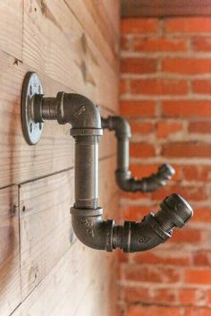 two pipes are attached to the side of a brick wall, and there is no image on it