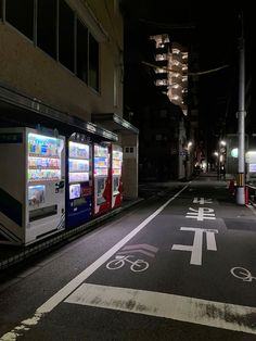 an empty street at night with vending machines