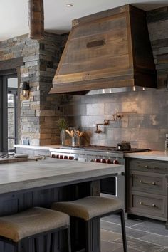 a kitchen with an island and two stools in front of the stove top oven