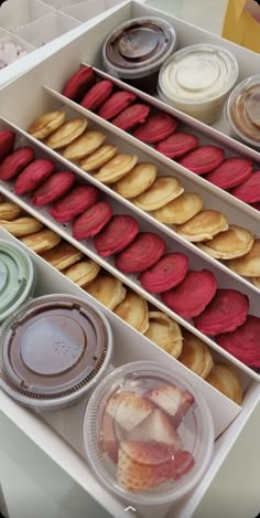 an open box filled with lots of different types of cookies and pastries on top of each other