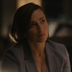 a woman in a suit looks off into the distance