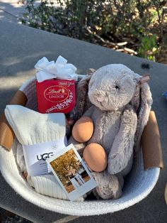 a stuffed animal sitting in a basket with other items