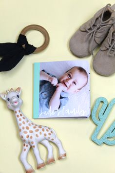 a baby's first year photo surrounded by toy animals and other items on a yellow surface