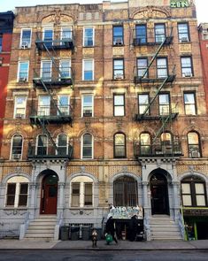 an apartment building with many windows and balconies on the top floor, next to a fire escape