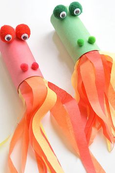 two paper tubes with googly eyes and orange streamers in the shape of carrots