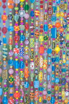 colorful beads hanging from the side of a building