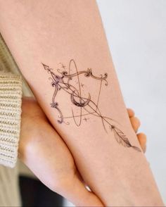 a woman's arm with an arrow tattoo on it