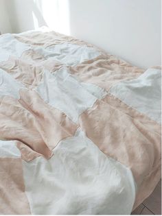 an unmade bed with pink and white sheets