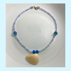 A natural shell necklace with blue glass beads offers a unique and eye-catching accessory that combines elements of nature and artistry. It can be a versatile addition to various outfits, adding a touch of coastal charm and elegance to both casual and formal ensembles.  Please keep in mind that each of our products is handmade and each one could be slightly different from the others! There may be variations in beads and charms due to supply chain availability. Any accessories or props shown in the pictures, other than the product itself, are not included with the purchase.  If you have any questions let us know! Support@Starfish.com  All items will ship within 1 to 3 days as they are handmade just for you! 🌸 Sign up for the Starfish by Kristan email list and get 15% off your order NOW! Af Blue Beaded Shell Necklace Ocean-inspired, Ocean-inspired Blue Beaded Shell Necklace, Blue Shell Jewelry With Colorful Beads, Ocean-inspired Blue Shell Jewelry, Blue Beaded Shell Strand Necklace, Blue Shell Necklace With Colorful Beads For Gift, Ocean-inspired Blue Shell Beaded Necklaces, Handmade Adjustable Blue Shell, Blue Handmade Adjustable Shell