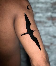 a black bird with a crescent moon tattoo on the arm