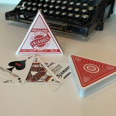 four playing cards sitting on top of a table next to an old fashioned typewriter