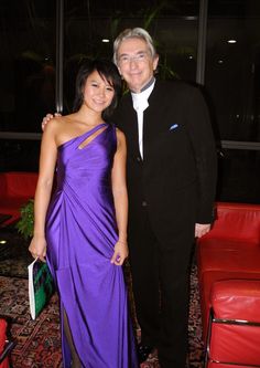 two people standing next to each other in formal wear