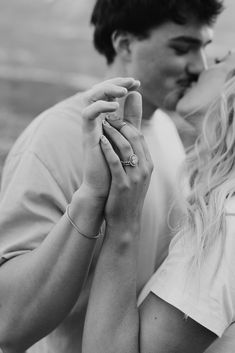 a man and woman kissing each other while holding hands